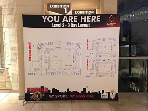 A banner-wall printed with a map of a conference centre showing directions