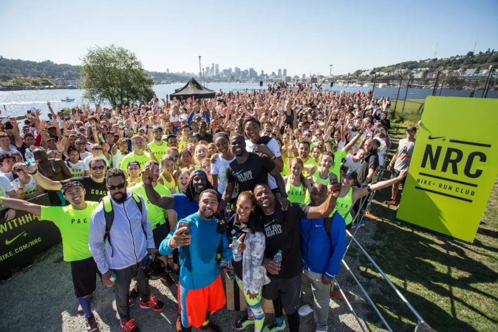Hundreds of runners at an outdoor Nike Run Club Event along with banners and gazebos printed with NRC branding.